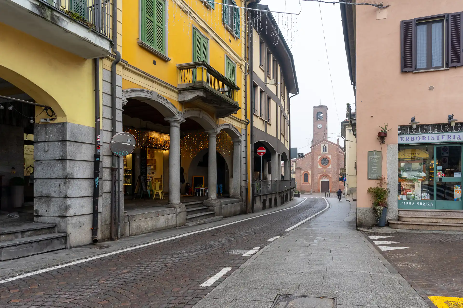 Centro storico di Melegnano con negozi e via pedonale verso la Basilica